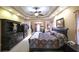 Luxurious main bedroom featuring a tray ceiling, dark wood furniture, and an adjacent sitting area at 893 Somersby Dr, Dallas, GA 30157
