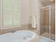 Serene bathroom showcasing a luxurious soaking tub, walk-in shower, and neutral tile at 208 Grandmar, Canton, GA 30115