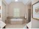 Serene bathroom showcasing a luxurious soaking tub, walk-in shower, and neutral tile at 208 Grandmar, Canton, GA 30115