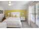 Bedroom featuring bright yellow wallpaper, white bed, ceiling fan and plenty of natural light at 208 Grandmar, Canton, GA 30115