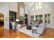 Spacious living room featuring hardwood floors, a stone fireplace, built-in bookshelves, and large windows at 208 Grandmar, Canton, GA 30115
