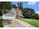 Well-maintained two-story home with a brick accent, green lawn, and an attached two-car garage with driveway at 228 Kensington Trce, Stockbridge, GA 30281