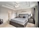 Main bedroom featuring tray ceiling, a bed and bedside tables at 228 Kensington Trce, Stockbridge, GA 30281