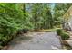 Backyard featuring mature trees, lush greenery, and hardscape ready for entertaining at 2436 Ovidia Sw Cir, Atlanta, GA 30311