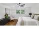 Bright bedroom with wood floors, ceiling fan, large window, dresser and chair at 2436 Ovidia Sw Cir, Atlanta, GA 30311