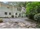 Rear exterior featuring a two-story white home with a lush backyard, patio and mature landscaping at 2436 Ovidia Sw Cir, Atlanta, GA 30311