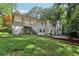 Exterior rear shot of a two-story home with stairs to a patio, a green lawn, and mature trees at 2436 Ovidia Sw Cir, Atlanta, GA 30311
