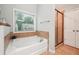 Bright bathroom boasts a soaking tub, separate shower, and natural light from a large window at 4710 Robins Nest Ln, Cumming, GA 30041