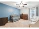 Charming bedroom featuring a crib, blue accent wall, and natural light, perfect for a Bedroom at 4710 Robins Nest Ln, Cumming, GA 30041