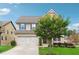 Inviting two-story home with a manicured lawn and attached garage and a lovely tree in the front yard at 4710 Robins Nest Ln, Cumming, GA 30041