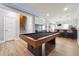 Open-concept game room featuring a billiard table, bar with seating, and living room at 4710 Robins Nest Ln, Cumming, GA 30041