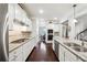 Spacious kitchen with white cabinets, granite countertops, stainless steel appliances, and a view of the dining area at 4710 Robins Nest Ln, Cumming, GA 30041