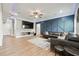 Spacious living area showcasing a sleek black sectional, patterned rug, and stylish blue accent wall at 4710 Robins Nest Ln, Cumming, GA 30041