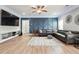 Inviting living room boasts stylish blue accent wall, modern furnishings, and a large flat-screen TV at 4710 Robins Nest Ln, Cumming, GA 30041