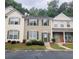 Traditional townhouse with neutral siding, green shutters, tidy lawn, and parking area at 4645 Valais Ct # 10, Johns Creek, GA 30022