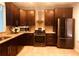 Modern kitchen with stainless steel appliances, granite countertops, and dark wood cabinets at 4645 Valais Ct # 10, Johns Creek, GA 30022