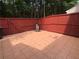 Private patio with tiled floor, framed by a red-stained wooden privacy fence at 4645 Valais Ct # 10, Johns Creek, GA 30022