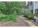 Lush backyard featuring mature trees, landscaping, and brick-lined mulch at 5015 Riverthur Pl, Peachtree Corners, GA 30096
