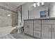 Clean bathroom featuring white marble tile and a grey double vanity with granite countertops at 5015 Riverthur Pl, Peachtree Corners, GA 30096
