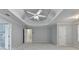 Expansive main bedroom boasts tray ceiling, fan, and bathroom and closet access at 5015 Riverthur Pl, Peachtree Corners, GA 30096