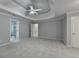 Large primary bedroom features a tray ceiling with ceiling fan and en-suite bathroom at 5015 Riverthur Pl, Peachtree Corners, GA 30096