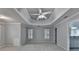 Bright primary bedroom with a tray ceiling, ceiling fan, and en-suite bathroom access at 5015 Riverthur Pl, Peachtree Corners, GA 30096