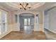 Open dining room with hardwood floors, white wainscoting, tray ceiling, and modern light fixture at 5015 Riverthur Pl, Peachtree Corners, GA 30096