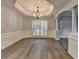 Bright dining room with wood floors, plantation shutters, detailed trim, and decorative lighting at 5015 Riverthur Pl, Peachtree Corners, GA 30096