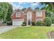 Two-story brick home featuring a manicured lawn and established landscaping enhancing its curb appeal at 5015 Riverthur Pl, Peachtree Corners, GA 30096