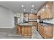 Spacious kitchen featuring an island, stainless steel appliances, granite countertops, and wood cabinets at 5015 Riverthur Pl, Peachtree Corners, GA 30096