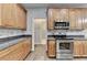 Well-lit kitchen featuring stainless steel appliances, wood cabinets, and granite countertops at 5015 Riverthur Pl, Peachtree Corners, GA 30096