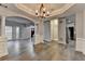 Open-concept living area with hardwood floors, columns, and access to the kitchen and entry at 5015 Riverthur Pl, Peachtree Corners, GA 30096