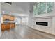 Open living room featuring a fireplace and hardwood flooring adjacent to kitchen at 5015 Riverthur Pl, Peachtree Corners, GA 30096