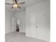 This bedroom features neutral walls, carpeted floors, a ceiling fan, and double closets at 5575 Mirror Lake Dr, Cumming, GA 30028