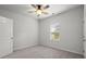 This bedroom features carpeted floors, a ceiling fan, and a window for natural light at 5575 Mirror Lake Dr, Cumming, GA 30028