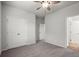 This bedroom features neutral walls, grey carpet, a ceiling fan, and double-door closet at 5575 Mirror Lake Dr, Cumming, GA 30028
