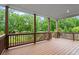 Large covered deck with wooden railings offers wooded views at 5575 Mirror Lake Dr, Cumming, GA 30028