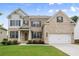 Charming brick two-story home features a manicured lawn and a two-car garage at 5575 Mirror Lake Dr, Cumming, GA 30028