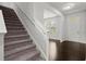 This foyer includes the staircase, dark wood floors, and a white front door at 5575 Mirror Lake Dr, Cumming, GA 30028