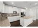 Bright kitchen features stainless appliances, granite counters, dark wood floors, and island with pendant lighting at 5575 Mirror Lake Dr, Cumming, GA 30028