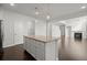 Open kitchen with center island and stainless appliances flows into the living room with a cozy fireplace at 5575 Mirror Lake Dr, Cumming, GA 30028