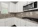 This well-appointed kitchen features granite countertops, modern appliances, and bright white cabinetry at 5575 Mirror Lake Dr, Cumming, GA 30028