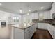 Open concept kitchen showcases island with seating and stainless appliances, flowing into living room with fireplace at 5575 Mirror Lake Dr, Cumming, GA 30028