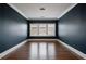 Empty bedroom with hardwood floors, modern trim, and three-pane windows at 5915 Read Rd, Suwanee, GA 30024