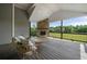 Inviting covered deck with stone fireplace and comfortable seating offering scenic views of the lush greenery at 5915 Read Rd, Suwanee, GA 30024