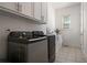 Well-equipped laundry room with modern washer and dryer, plus built-in storage and natural light at 5915 Read Rd, Suwanee, GA 30024