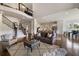 Spacious living room with an open staircase, hardwood floors, and a view of the modern kitchen at 5915 Read Rd, Suwanee, GA 30024