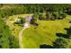 Expansive aerial view showcases a home on a large lot with a long driveway, bordered by mature trees and a manicured lawn at 197 Westbrook Rd, Carrollton, GA 30116