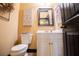 Small half bath displaying a white vanity, mirror, and toilet at 197 Westbrook Rd, Carrollton, GA 30116