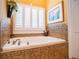 A luxurious bathroom with a tiled tub, white shutters, and elegant fixtures at 197 Westbrook Rd, Carrollton, GA 30116